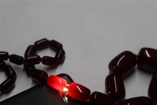 A single strand graduated simulated dark cherry amber necklace, gross weight, 98 grams,